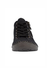 Basket noire avec fermeture à lacets, fermeture éclair sur le côté, semelle texturée et surpiqûres contrastantes autour de l'orteil. Présente une forme arrondie.