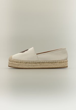 Εσπαντρίγια από εκρού καμβά με χοντρή πλεκτή σόλα από γιούτα και σκούρο καφέ κυκλική επιφάνεια στο μπροστινό μέρος.