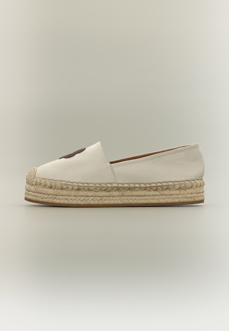 Εσπαντρίγια από εκρού καμβά με χοντρή πλεκτή σόλα από γιούτα και σκούρο καφέ κυκλική επιφάνεια στο μπροστινό μέρος.