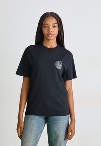 Black cotton t-shirt with a round neckline and short sleeves. Features a small, detailed graphic on the left chest area.