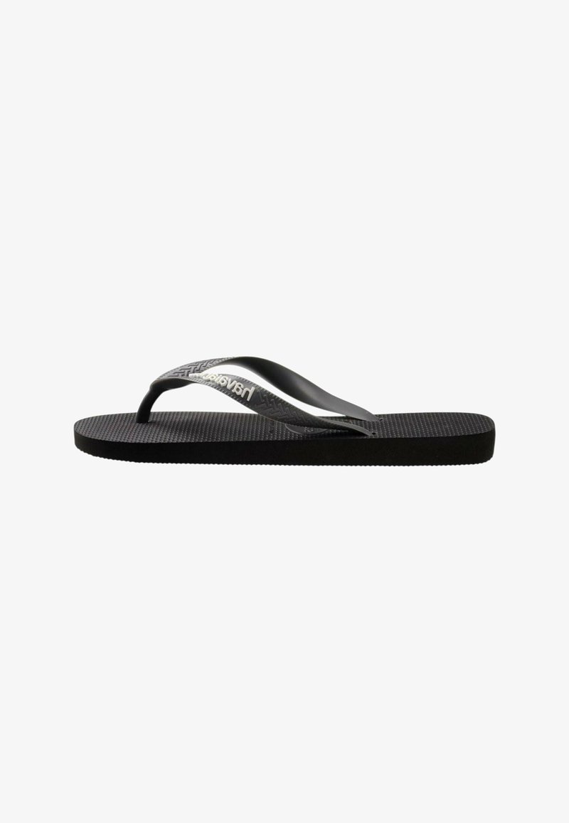 Chanclas de goma negra con plantilla texturizada y tiras delgadas y curvas. Presenta el logo de la marca en la tira en color plateado y un diseño de suela plana.