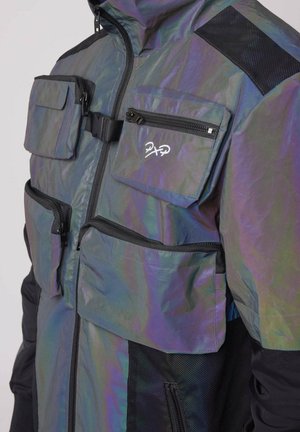 Giacca riflettente con multiple tasche con zip, dettagli neri e colletto alto. Presenta una finitura lucida e un tessuto leggero.