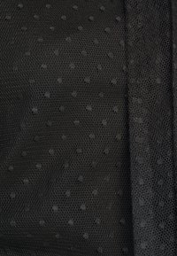 Tissu en maille noire avec de petits points en relief et une texture en filet hexagonal fin.