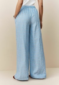 Blauwe en witte geruit brede broek met een gestructureerde stof, elastische tailleband en zijzakken.