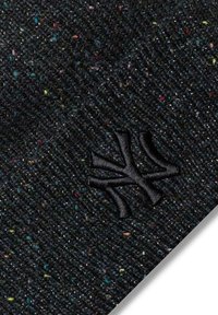 Zwarte gebreide beanie met een textuurpatroon, volop kleurrijke spikkels. Een zwart geborduurd logo bevindt zich aan de voorkant.