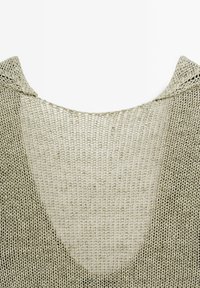 Sweter dzianinowy z szerokim dekoltem i otwartym tyłem. Wykonany z fakturowanej, jasnorazowej przędzy, charakteryzuje się luźnym splotem i swobodnym krojem.