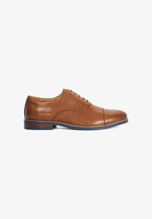 Chaussure Oxford pour homme en cuir marron avec bout droit, laçage fermé et semelle foncée avec un petit talon empilé.