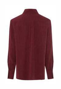 Burgundy long-sleeve shirt with a collar, pleat detail at the back, buttoned cuffs, and smooth texture.