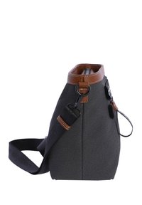 Bolso tote de tela gris con detalles en cuero marrón, una correa desmontable y cierre de cremallera. Presenta una forma estructurada y detalles de costura visibles.