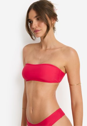 Rotes Bandeau-Bikinioberteil aus glattem Stoff, mit minimalistischem Design ohne Träger. Die Unterteile sind im Hipster-Stil und farblich abgestimmt.