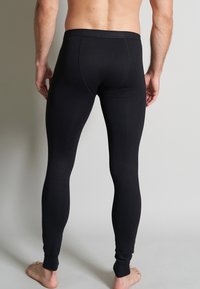 Black stretchy leggings with a smooth texture, form-fitting silhouette, and ankle cuffs. Waistband is sturdy and elastic without visible markings.