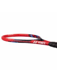 Yonex badminton racket featuring a red and black frame with blue accents, an isometric shape, and a textured grip handle.