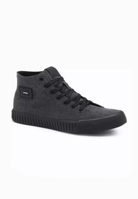 Zapatillas altas negras de lona con cordones planos, suela de goma texturizada y un pequeño parche con logo en el costado.