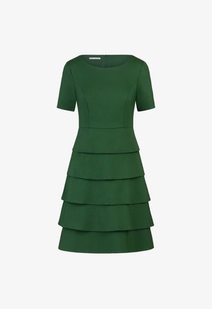 Groene jurk met een ronde halslijn, korte mouwen en een gelaagd ontwerp met vier horizontale lagen. Glad stoftextuur, ritssluiting aan de achterkant.
