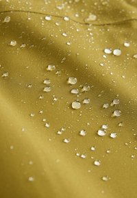 Țesătură cu o finisare netedă și mată de culoare verde măsliniu, având picături de apă pe suprafață, evidențiind proprietățile sale rezistente la apă.