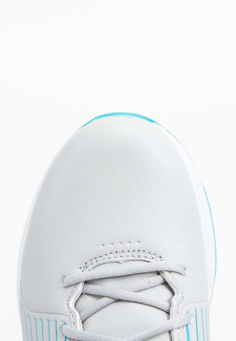 Primer plano de la punta de una zapatilla blanca con acentos en azul claro y cordones blancos entrelazados sobre un fondo blanco limpio.