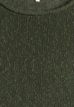 Gros plan sur un tissu tricoté vert montrant des mailles verticales côtelées détaillées avec un bord de col texturé.