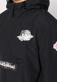 Zwarte capuchonjack met een half-rits ontwerp, voorzien van een geprinte cherubijn graphic aan de voorkant en een logo patch. Glad textuur.