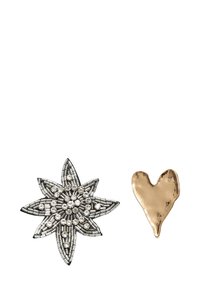 To brocher: et sølvstjerneformet design med rhinsten og et guld hjerteformet broche med en glat, let struktureret overflade.