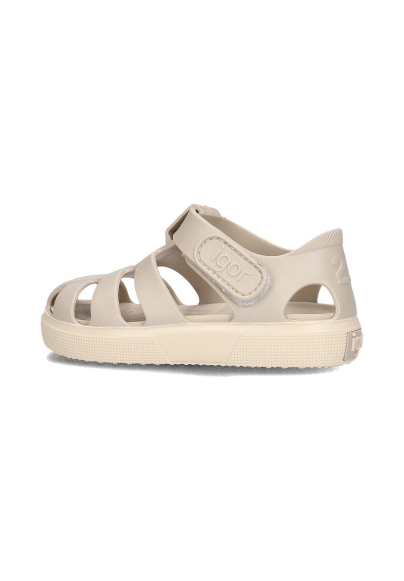 Beige plastic sandals with open toe and side vents, secured by a Velcro strap, featuring a textured sole and brand logo on the heel.
