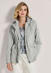 Hellgraue wasserdichte Jacke mit Kapuze, ausgestattet mit zwei Fronttaschen, verstellbarem Kordelzug und einer glatten Stoffstruktur.