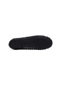 Zapatilla negra de tejido con suela texturizada, que cuenta con una base de goma y un diseño superior flexible y transpirable.