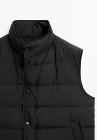 Gilet imbottito nero con colletto alto, chiusura con bottoni, texture trapuntata e design senza maniche. Presenta due tasche laterali e una finitura opaca.