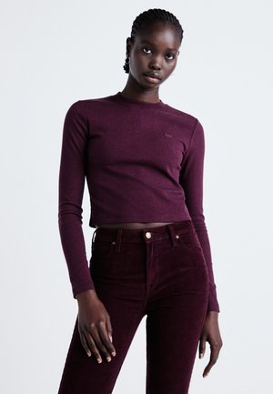 Burgundia pikkade varrukatega tops, ribakujundusega, koos kõrge vöökohaga burgundia puuvillaste pükstega. Minimalistlik disain, peen logo detail.
