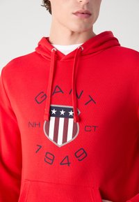 GANT PRINT HOODIE - Jersey con capucha - bright red
