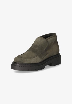Stevige donkergroene suède loafer met dikke zwarte profielzool en brede band over de wreef, schuin getoond op een witte achtergrond.