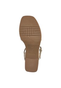 Brown rubber outsole with textured grip patterns; rectangular heel; branded "Toms" and "Anti-Slide" marks; open strap design.