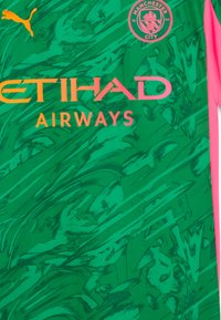 Grön sporttröja med abstrakta mönster, en rosa accent och en stor "ETIHAD AIRWAYS"-logotyp i orange. Puma-logotyp och Manchester City-vapen ingår.
