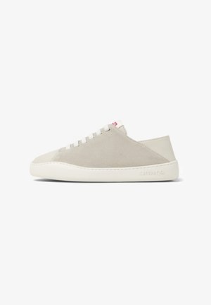 Beżowe zamszowe sneakersy z gładką białą gumową podeszwą. Posiadają niską cholewkę, okrągły czubek i białe sznurówki. Dyskretne logo na pięcie.