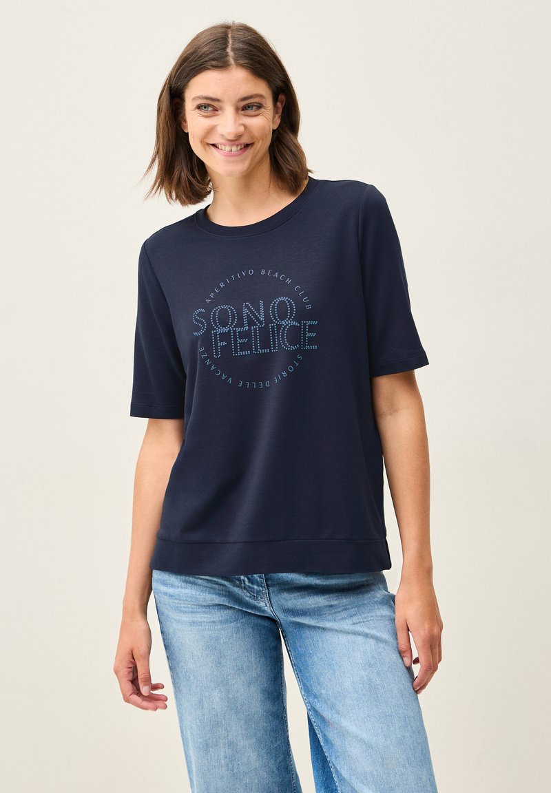 T-shirt bleu marine à manches courtes en tissu doux, avec un design imprimé circulaire de texte « SONO FELICE » en bleu clair. Texture lisse.