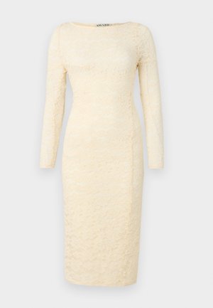 Robe en dentelle crème à manches longues, décolleté rond et silhouette ajustée. Présente un motif floral et un ourlet à hauteur des genoux.