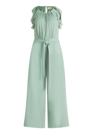 Hihaton vaaleanvihreä haalari, jossa on röyhelöiset olkapääyksityiskohdat, kerätty vyötärö, etuosasta solmittu kangasvyö ja leveälahkeiset housut.