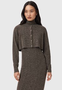 Hnedý rebrovaný sveter s krátkym strihom a vysokým golierom, s zapínaním na gombíky vpredu a textúrovanou tkaninou.