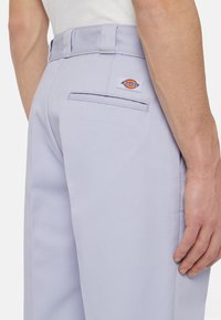 Lilas arbeidsbukser laget av slitesterkt stoff, med rett snitt, baklomme og en logo-patch p�å midjebåndet.