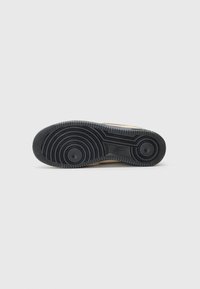 Sneakersålen har et sort gummimateriale med cirkulære dækmønstre og hævede teksturerede accenter, der giver greb og holdbarhed.