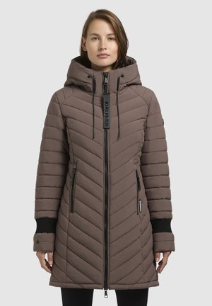 Barna, steppelt télikabát kapucnival, teljes cipzárral, két oldalsó zsebbel és fekete bordázott mandzsettákkal. Geometrikus chevron minta az egész felületen.