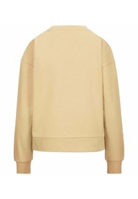 Sudadera de un beige claro con un corte relajado, cuello redondo y mangas largas. La tela parece suave, con una textura lisa y puños acanalados.