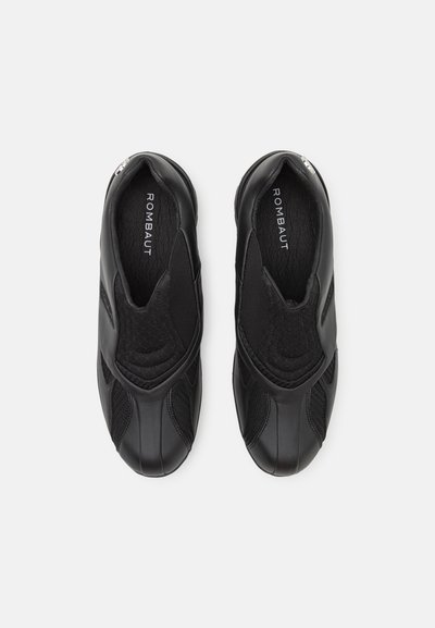 Chaussures noires à enfiler avec un dessus texturé, combinant du cuir lisse et des panneaux en mesh, présentant un bout rond et un minimalisme dans les détails.
