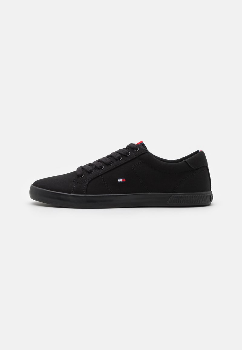Juodi sneakersai, pagaminti iš zomšos su lygia apdaila, su apvaliu pirštu, raišteliu priekine dalimi ir subtiliu logotipo detaliu šone.