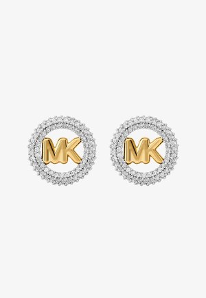 Zlatni "MK" logo naušnice okružene su kružnim okvirom malih prozirnih kristala. Srebrni akcenti ističu složeni dizajn.