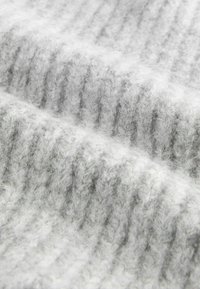 Tessuto grigio lavorato a maglia con texture a coste, fibre morbide e una leggera peluria, che creano un aspetto caldo e accogliente.