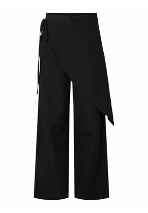 Pantalon large noir avec un sur-jupe asymétrique nouée à la taille gauche.