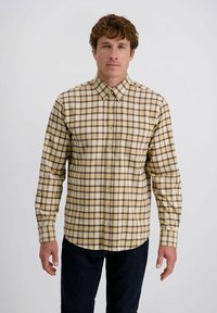 Geel en bruine geruite blouse met lange mouwen, een button-down kraag en knopen aan de voorkant, gedragen met donkere jeans. Gladde stofstructuur.
