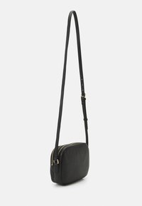 Borsa a tracolla nera in pelle con forma rettangolare, zip dorata, tracolla regolabile e texture liscia. Progettata per un uso informale.