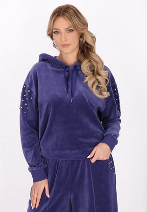 Hanorac din velur violet cu un buzunar frontal, decorat cu embellismente din metal argintiu pe mâneci și cu o glugă cu șnur. Textură moale.