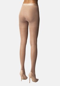 Hudfärgade nätstrumpbyxor med mönstrad struktur, hög midja och förstärkt tå, kombinerade med matchande högklackade skor.